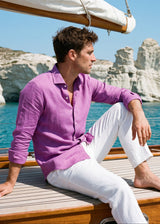 Laos Long Sleeve Linen Shirt in Orchid Belgian linen, side view with seashell buttons and rolled sleeves, on a sail yacht at Kleftiko, Milos.