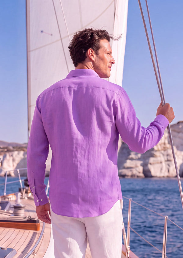 Laos Long Sleeve Linen Shirt in Orchid Belgian linen, back view showing the yoke and curved hem, on the deck of a sail yacht off Milos.