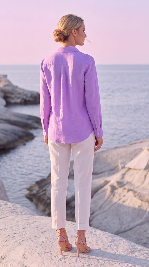 PP Linen Blouse in Orchid Belgian linen, back view showing curved hem and buttoned cuffs, overlooking the sea at Milos.
